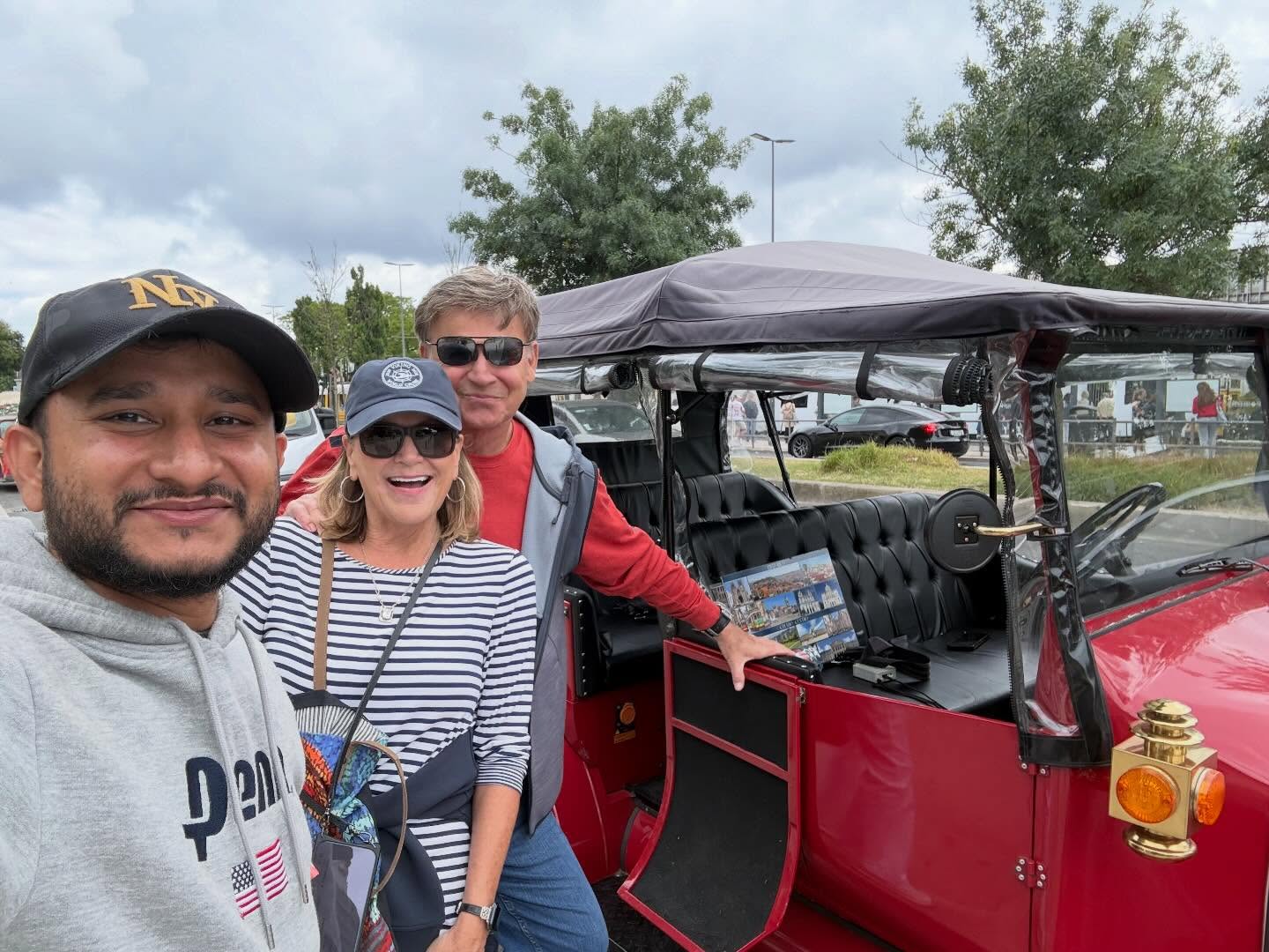 Happy customers with tour guide on a tuk tuk tour in Lisbon